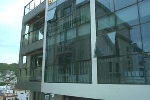 A modern multi-story building with large glass windows and balconies. - Shengsi Yihai House B & B (Shengsi)