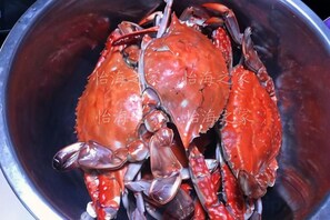 A metal bowl containing a crab.