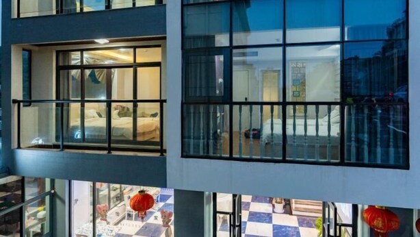 Ein Hotel mit mehreren Stockwerken, großen Fenstern und einem Schachbrettmuster auf dem Boden.