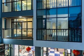 Un hôtel à étages, doté de grandes fenêtres et d’un sol à motifs carrés.