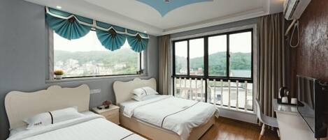 A hotel room with two beds, a large window with curtains, a balcony, and a TV.
