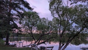 A lakeside setting with a bench, a picnic table, and a fire pit. - Studio Loft #9 at Riverside Point Resort (Park Rapids)