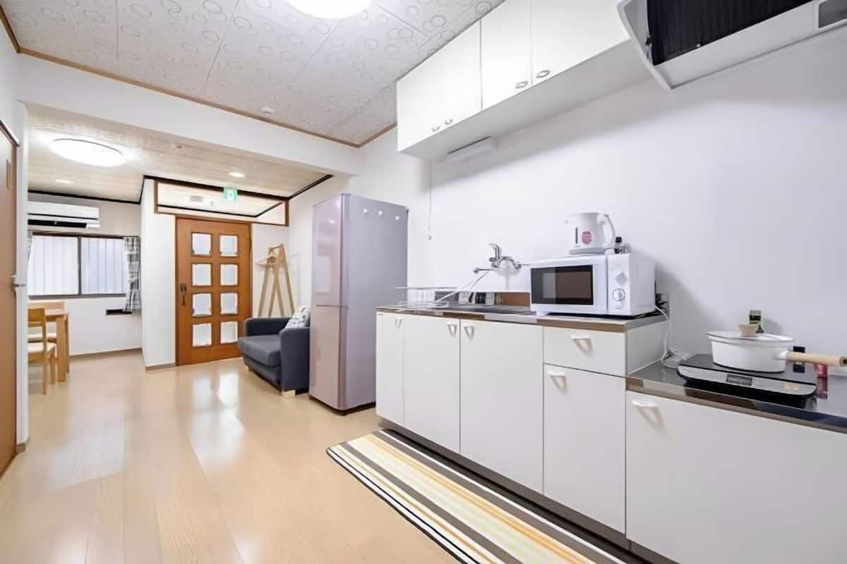 A modern kitchen with white cabinets, a microwave, and a refrigerator.