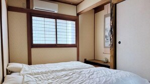 Une pièce avec un lit, une fenêtre et une porte.