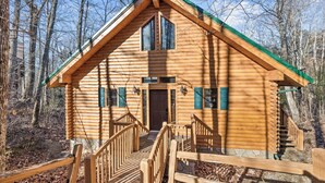 A log cabin with a central entrance, a staircase leading to the main floor, and a porch with railings. - Mountain Views from Sofa and Huge Deck! (Gatlinburg)