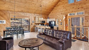 A spacious wooden cabin with a living area, kitchen, and dining space. - Mountain Views from Sofa and Huge Deck! (Gatlinburg)