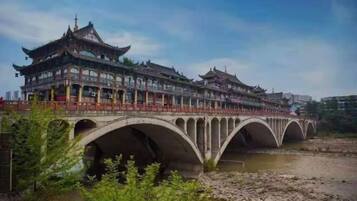 A traditional multi-story building with a series of arches supporting a bridge over a river.