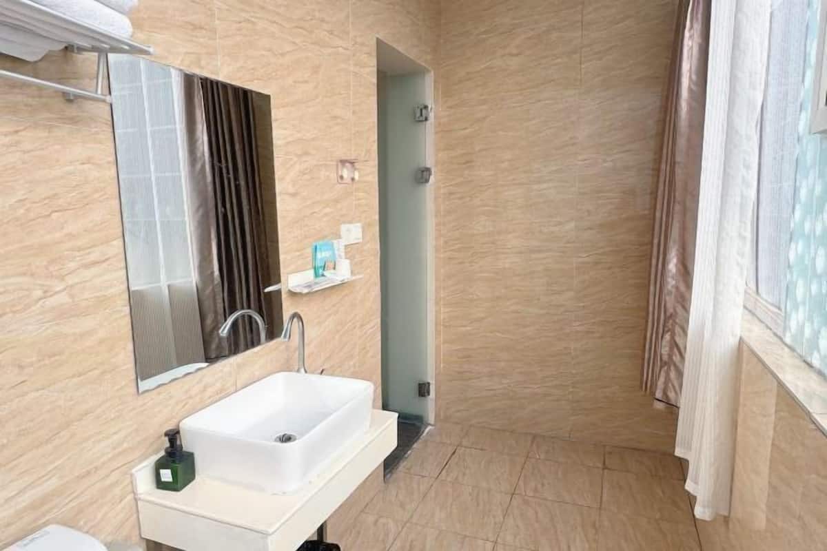 Un baño con lavamanos, espejo y ducha.