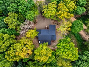 Un petit bâtiment d’un seul étage, entouré d’une végétation luxuriante, sous un ciel dégagé.