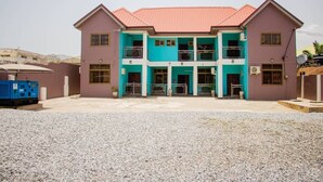 A two-story building with a red roof and a central entrance. - Accra Cosy Homes (Ngleshi Amanfro)