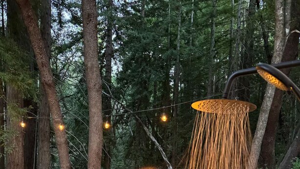 Een terras met een vuurkuil, Adirondack-stoelen en een jacuzzi.