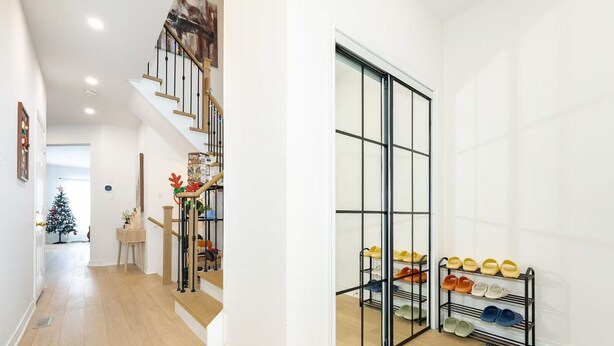 Una escalera con una puerta de vidrio que da a un zapatero.