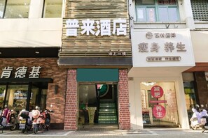Fachada de un edificio con varios establecimientos comerciales, incluyendo un hotel y un centro de bienestar.