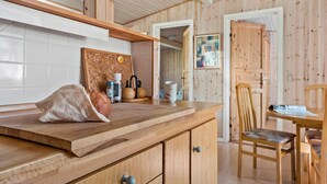Eine Holz-Küche mit Korktafel, Brotlaib und Kaffeemaschine.