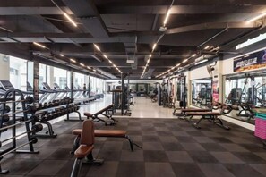 A gym with treadmills, weight machines, and benches.