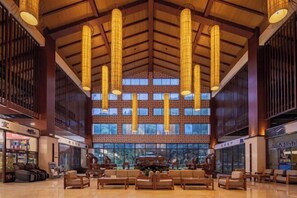 A spacious lobby with high ceilings, large windows, and a grand piano. - Wufeng International Hotel (Wufeng)