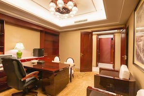A hotel room with a desk, chairs, a telephone, a lamp, and a large mirror. - Wufeng International Hotel (Wufeng)