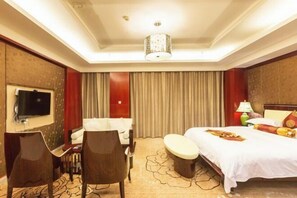 A hotel room with a bed, a TV, a desk, and a chair. - Wufeng International Hotel (Wufeng)