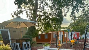 Un espace patio avec un foyer extérieur, des sièges de jardin et un pot de fleurs.