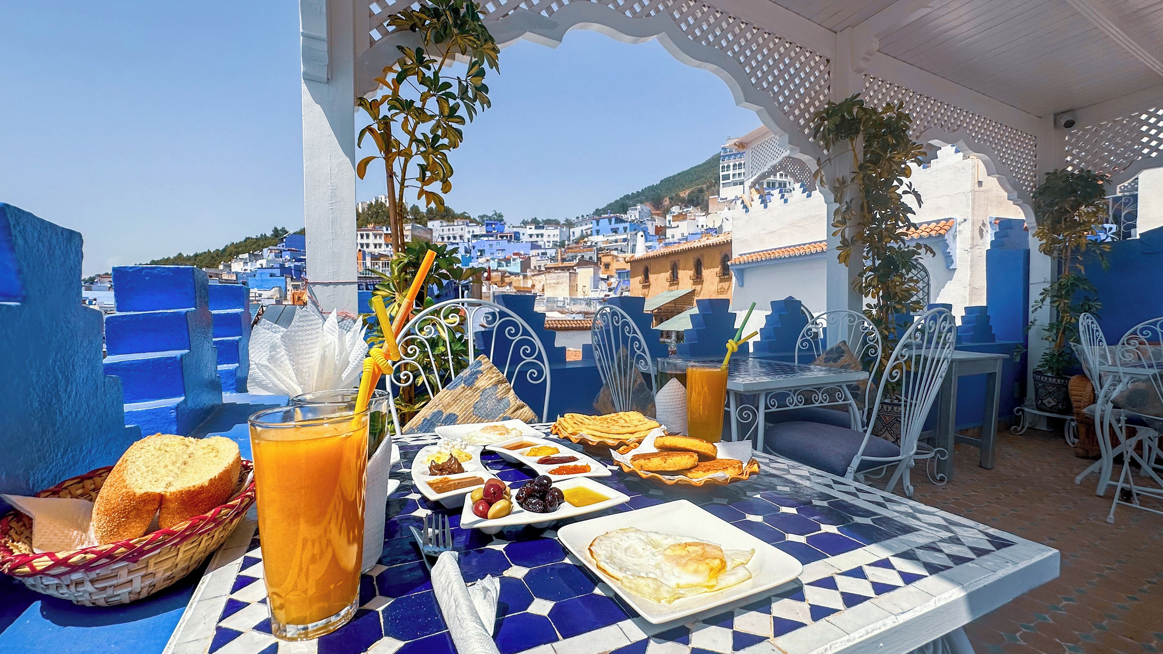 Un área de comedor al aire libre con vista a un paisaje urbano azul y blanco.