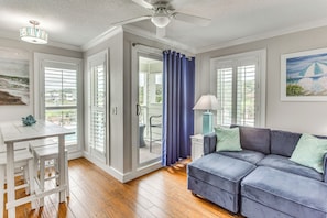 Relax in this inviting living area with a comfortable sofa, dining table, and ample natural light.