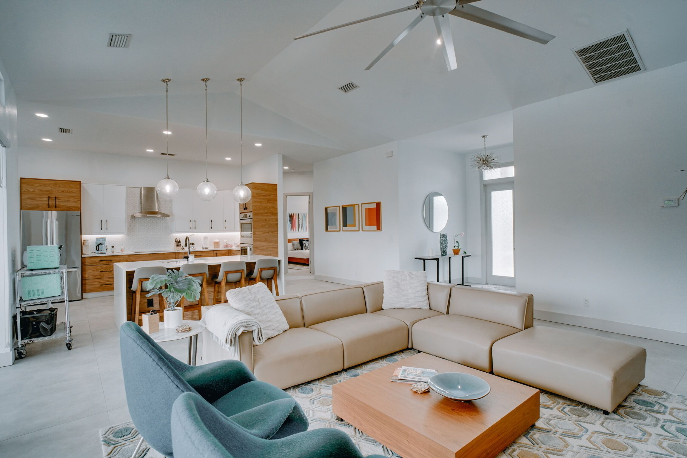 Un salon moderne avec un canapé d’angle, une table basse et un coin repas avec des chaises.