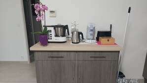 A kitchen counter with a coffee maker, a kettle, a toaster, and a box. - New house with all comforts! (Ajac)