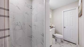 Chuveiro, secador de cabelo, toalhas de banho, sabonete