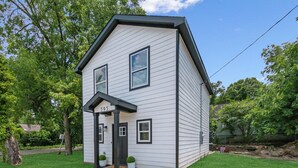 A two-story house with a gabled roof, a front porch, and a mailbox.