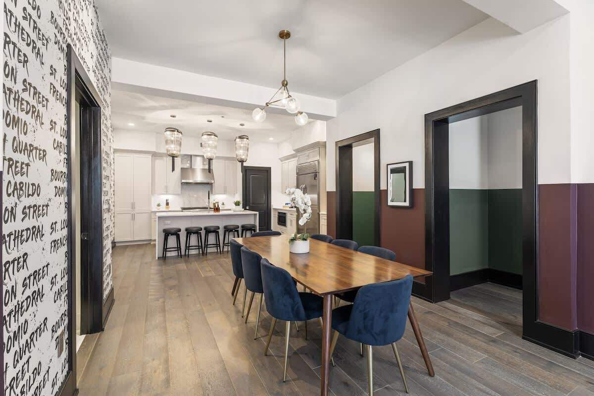 A modern kitchen with a central island, bar stools, and pendant lighting.
