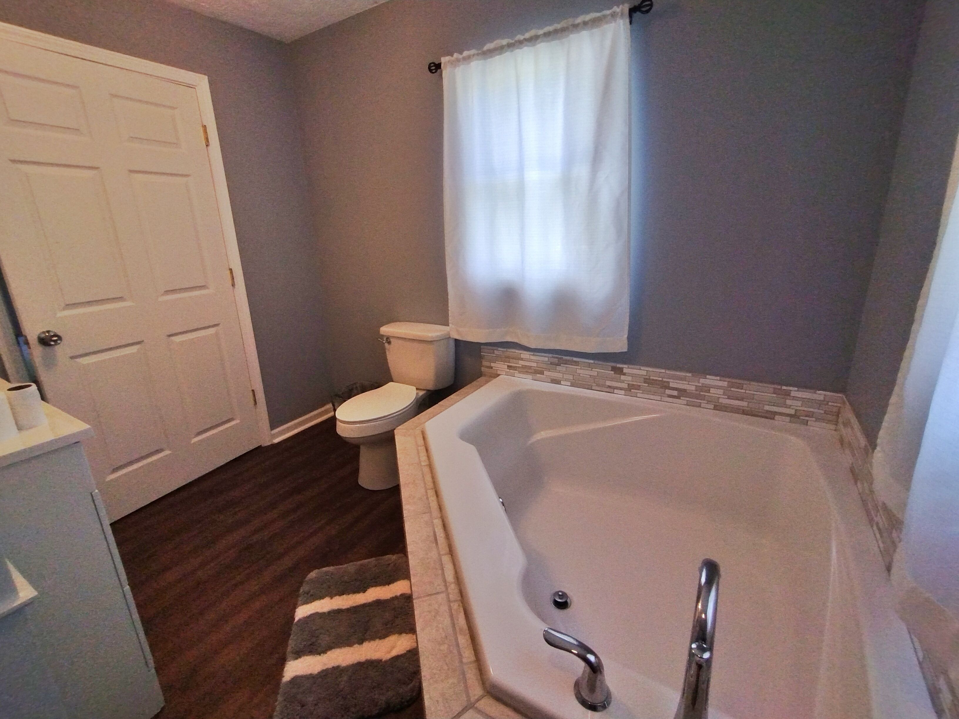 A bathroom with a toilet, bathtub, and a shower curtain.