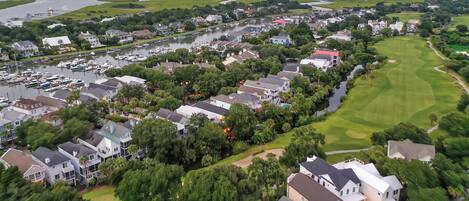 Vista aérea de una zona residencial con casas, un campo de golf y un puerto deportivo.