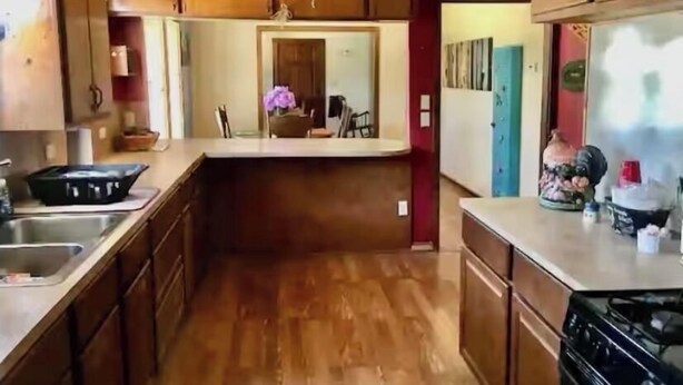 A kitchen with wooden cabinets, a sink, and a stove. - Charming 2-bedroom house in Coleman with AC and WiFi.  Sleeps 6 & no pets. (Coleman)