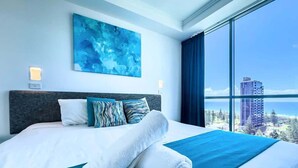 A hotel room with a large bed, a view of the ocean, and a modern design. - Broadbeach Ocean-View Beachfront Apartment (Broadbeach)