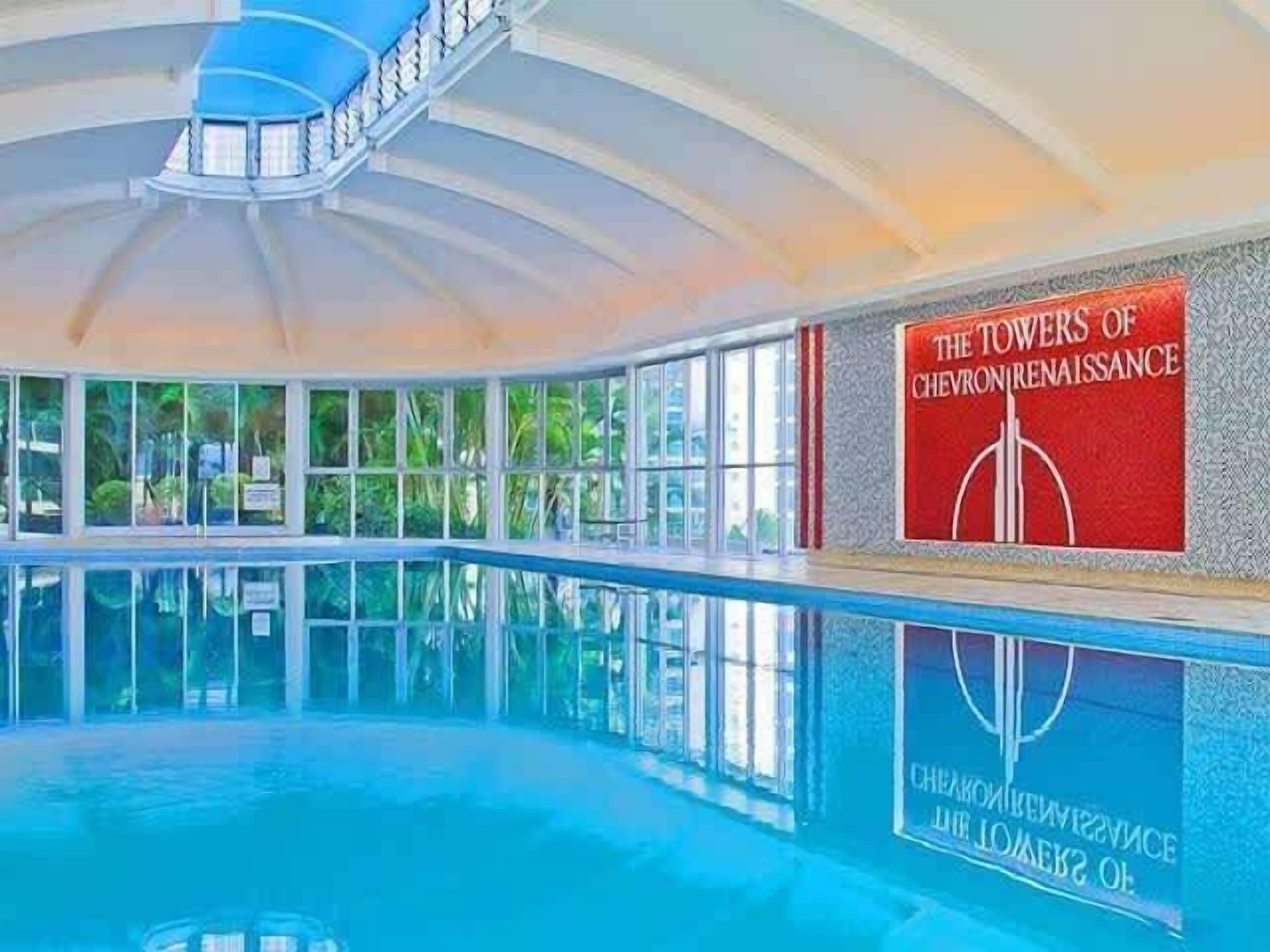 An indoor swimming pool with a view of greenery outside.