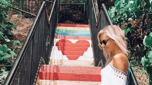 A staircase with a rainbow stripe pattern and a heart design in the middle.