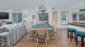 A dining area with a large table, chairs, and a television in the background. - 4603-Yellow Brick Road - Southern Shores Escape w/ Pool & Hot Tub (Southern Shores)