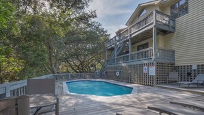 A wooden deck with a swimming pool, outdoor furniture, and a multi-level building with balconies. - 4603-Yellow Brick Road - Southern Shores Escape w/ Pool & Hot Tub (Southern Shores)