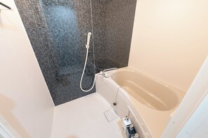 A modern bathroom with a bathtub and a shower area. - Provence Hotel (Tokyo)