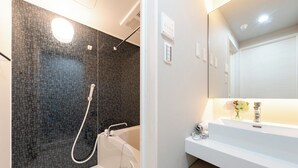 Ein modernes Badezimmer mit Duschwand aus Mosaikfliesen, einer weißen Badewanne und einem Waschtisch mit Spiegel.