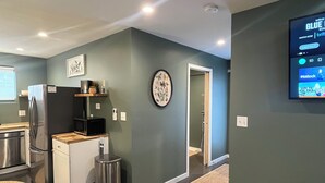 A modern kitchen with stainless steel appliances, a microwave, and a trash can. - Charming Eastham Guesthouse (Charlottesville)