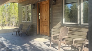 A wooden exterior with a front door, two windows, and three Adirondack chairs on a concrete porch. - Newer 3-bedroom cabin in fantastic Two Rivers North, free WiFi (Crescent Lake)