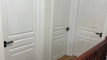 Conjunt de portes blanques amb nassos negres, sòl de fusta i barana de fusta.