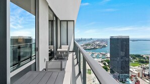 Un balcón con vista a un puerto deportivo y un edificio alto.
