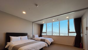 Ein Hotelzimmer mit zwei Betten, einem großen Fenster mit Ausblick und einem Feuerlöscher.