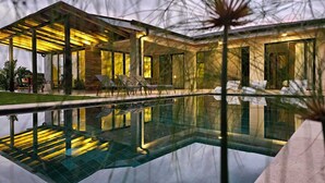 A modern house with a swimming pool, outdoor seating, and a well-lit patio area. - Villa Bosque (La Fortuna)
