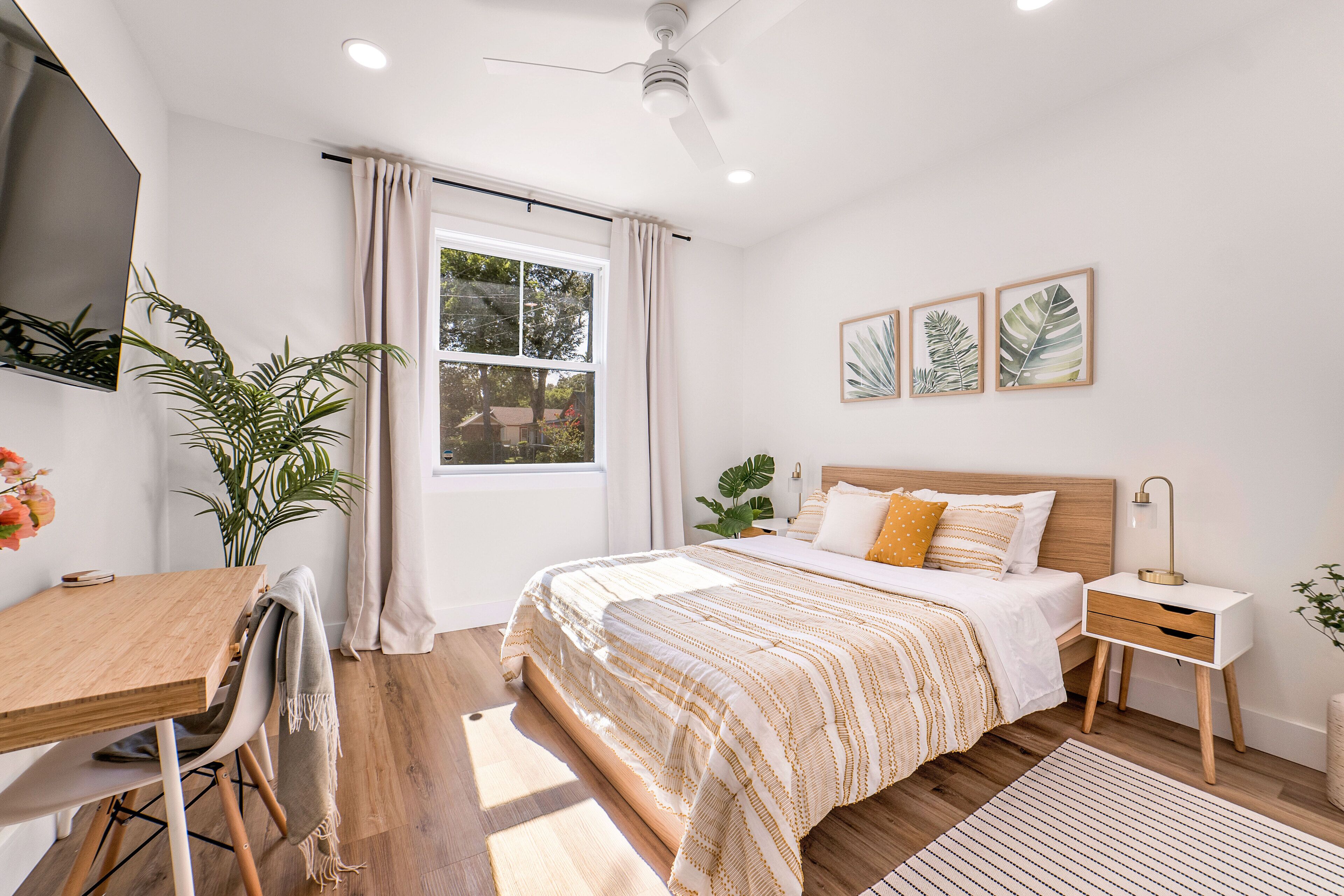 Quarto moderno com cama de madeira, uma escrivaninha e uma cadeira.
