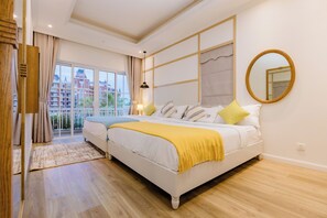 A bedroom with a large bed, a view of a building through a glass door, and a mirror on the wall.