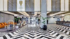 A spacious lobby with a modern design, featuring a chevron-patterned floor, seating areas, and a reception desk. - Sinpas Queen Bomonti Residence By Bondy (Istanbul)