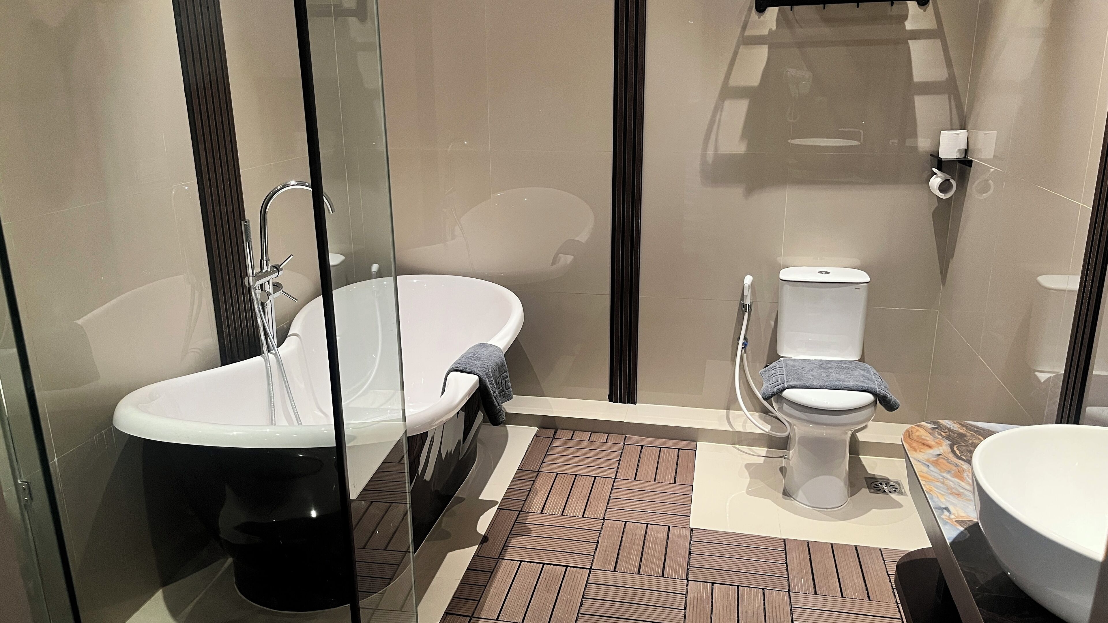 Ein modernes Badezimmer mit freistehender Badewanne, Toilette und Waschbecken.